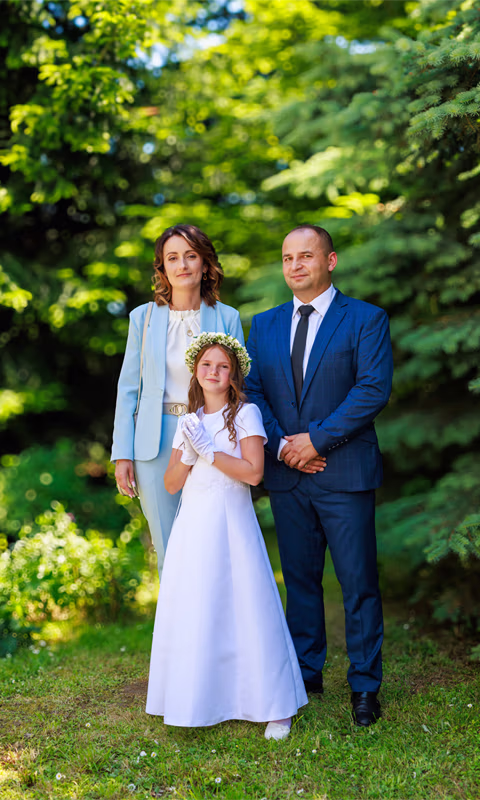 dziewczynka z rodzicami po komunii